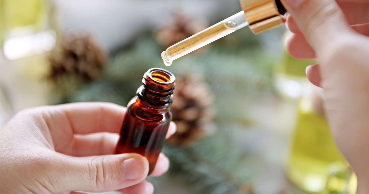 extracting essential oil using a dropper from a bottle