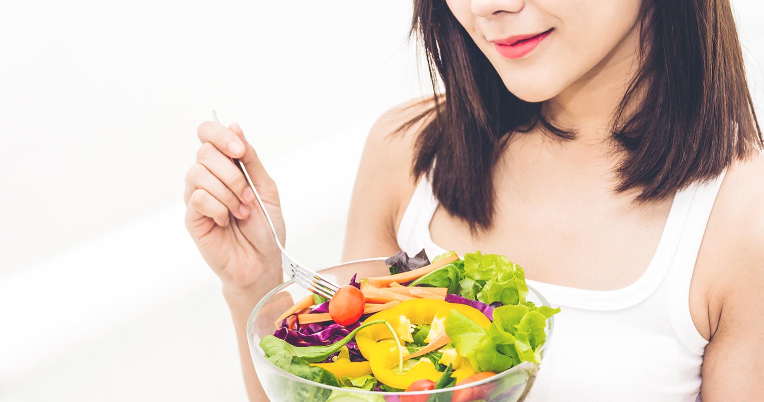 beautiful lady eating a bowl of salad