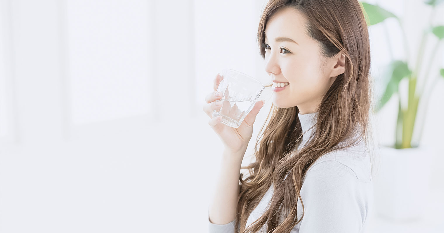 girl hydrating herself by drinking a glass of water