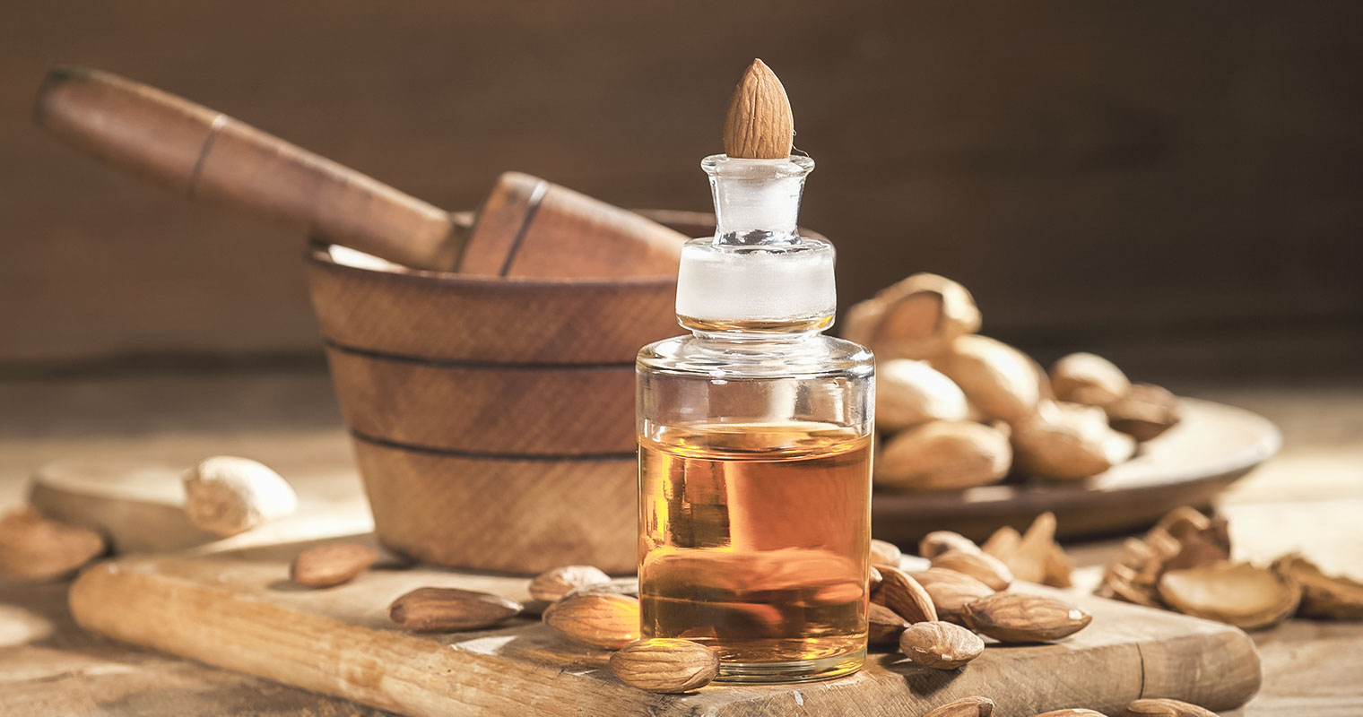 A bottle of Almond oil with a piece of Almond at the cap of the bottle