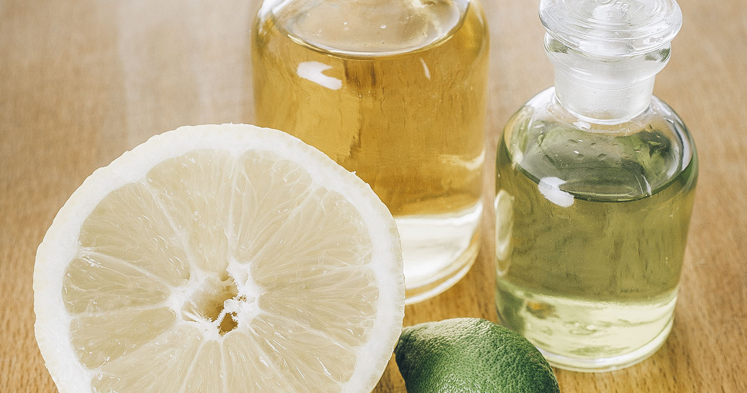 Cut open Lemon with bottle of Lemon juice and Lemon essential oil