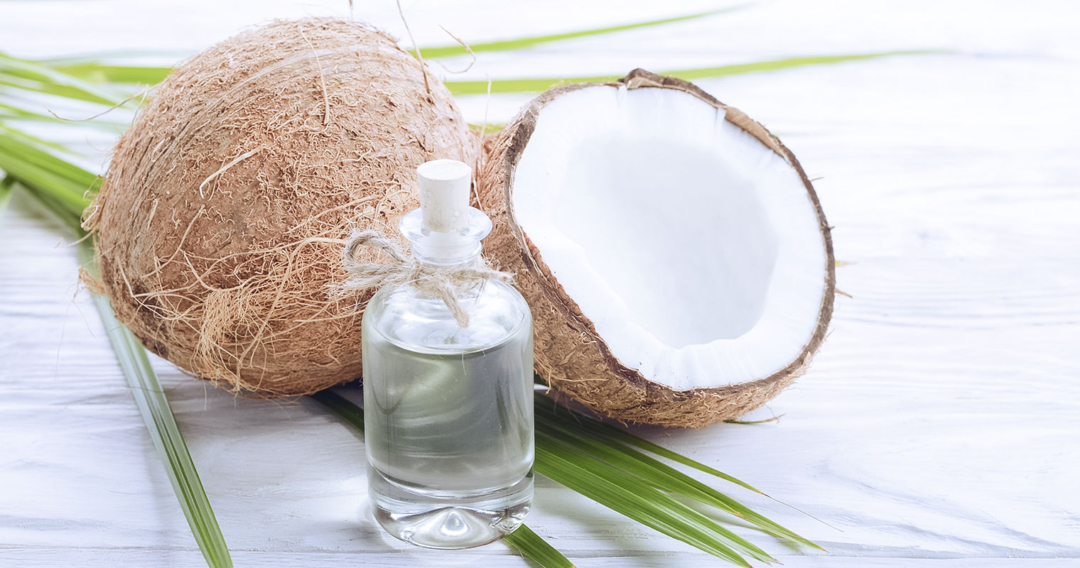 Opened coconut and a bottle of coconut oil