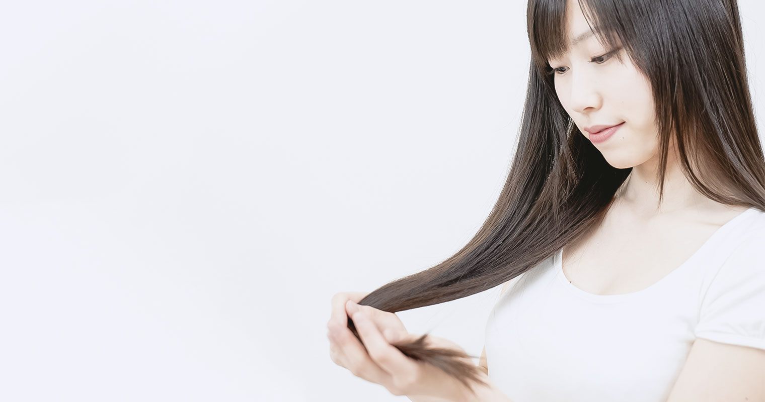 beautiful asian woman taking care of long straight hair
